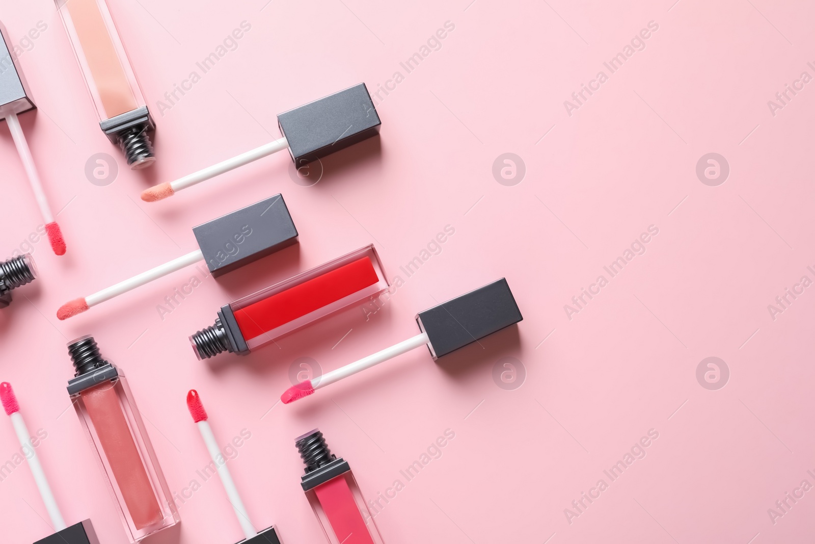 Photo of Composition of liquid lipsticks on color background, flat lay. Space for text