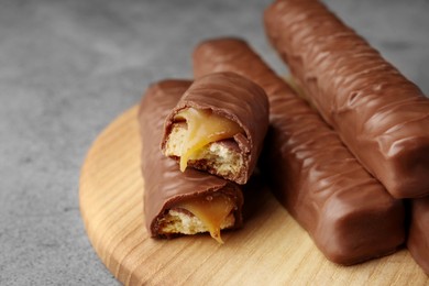 Photo of Sweet tasty chocolate bars with caramel on grey table, closeup