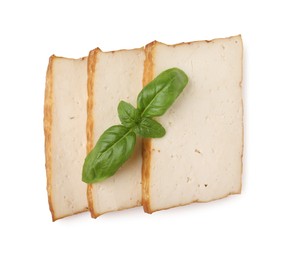 Photo of Slices of delicious smoked tofu and basil isolated on white, top view