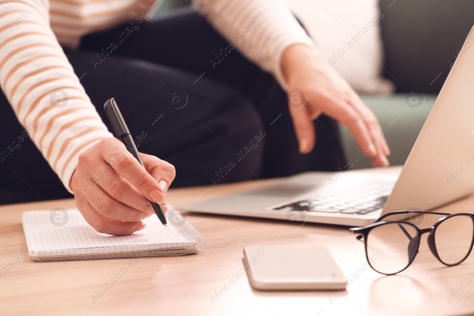 Photo of Woman with modern laptop learning at table indoors, closeup
