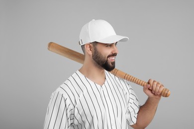 Photo of Man in stylish white baseball cap holding bat on light grey background