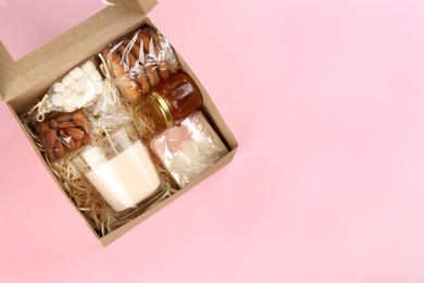 Photo of Stylish gift set on pink background, top view. Space for text