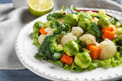Photo of Plate of salad with Brussels sprouts on table, closeup
