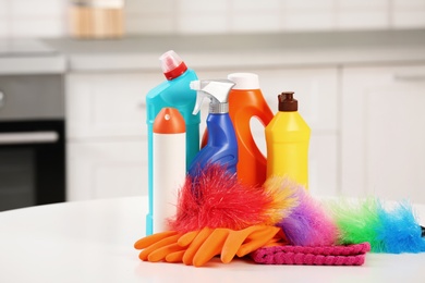 Photo of Set of cleaning supplies on table in kitchen