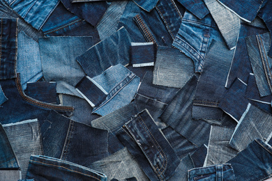 Photo of Many patches of old jeans as background, top view