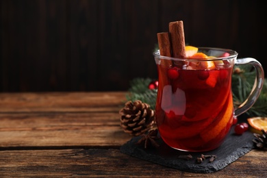 Photo of Tasty aromatic mulled wine on wooden table. Space for text