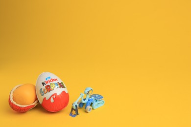 Photo of Sveti Vlas, Bulgaria - July 3, 2023: Kinder Surprise Eggs, plastic capsule and toy on yellow background, space for text