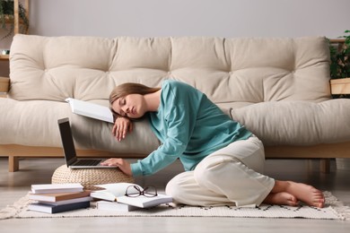 Photo of Young tired woman sleeping near couch at home