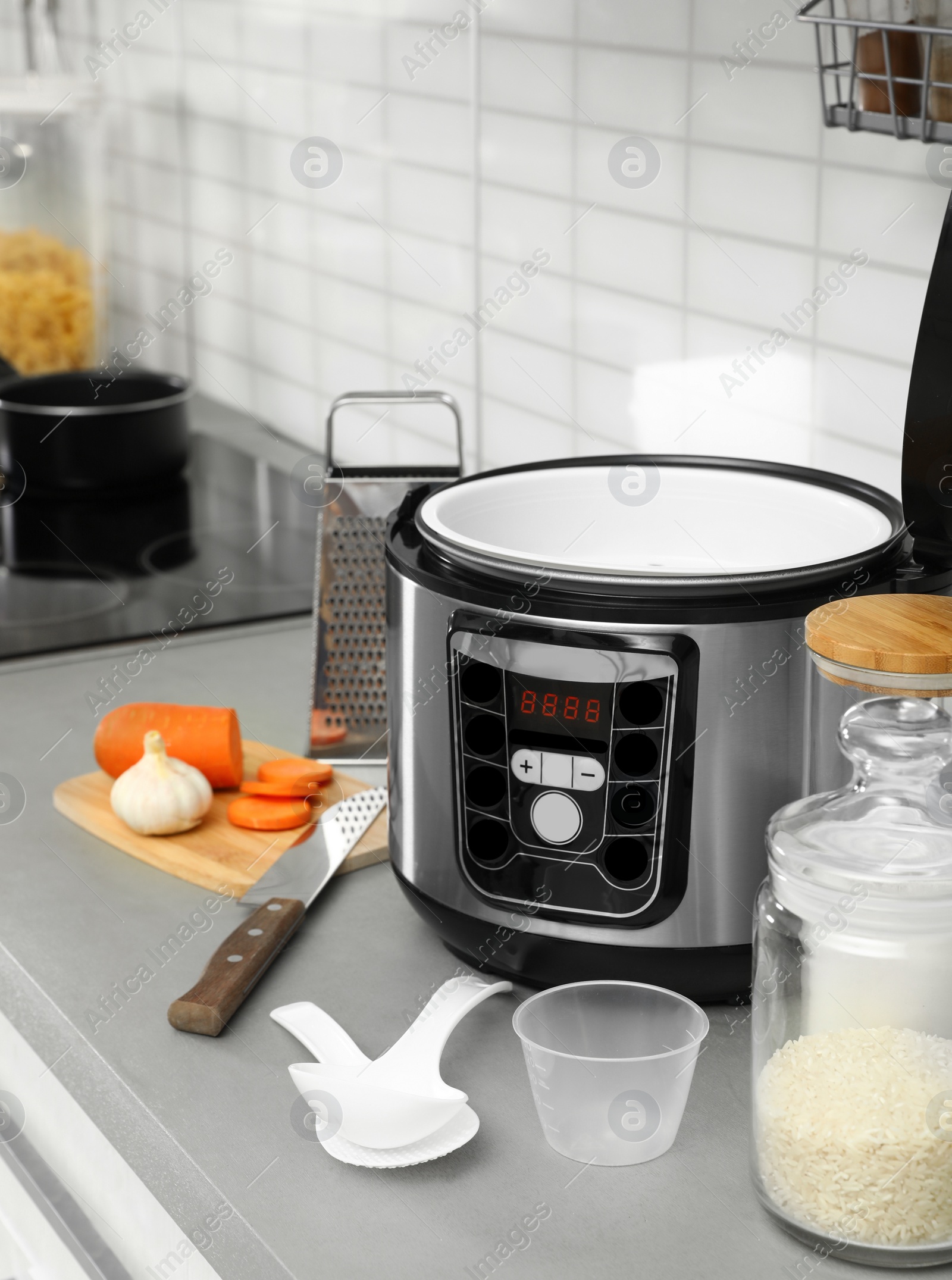 Photo of Modern multi cooker and products on table in kitchen. Space for text