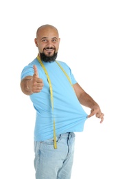 Photo of Overweight man with measuring tape on white background