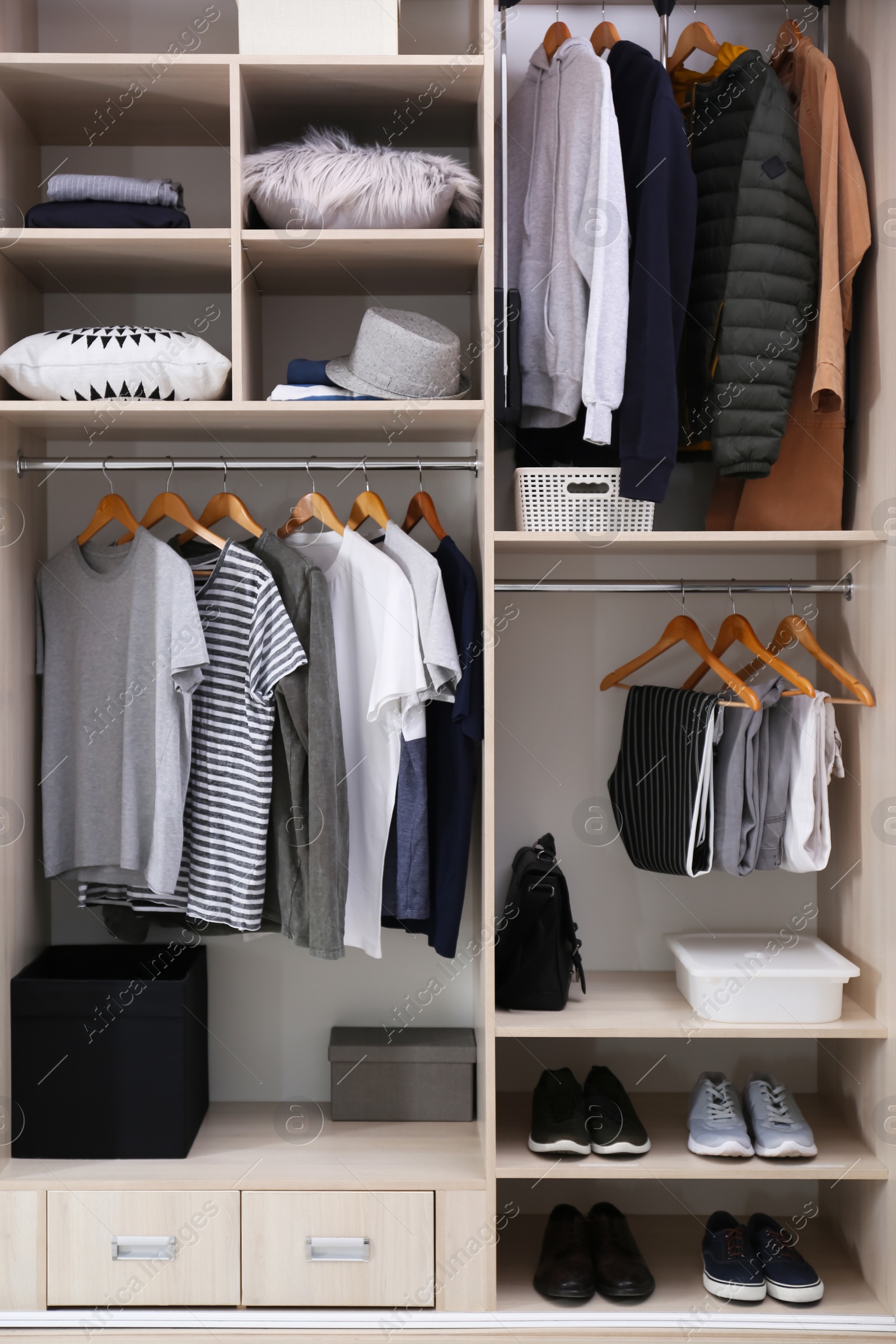 Photo of Stylish clothes, shoes and home stuff in large wardrobe closet