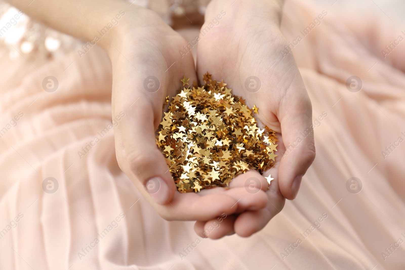 Photo of Woman holding confetti stars, closeup. Christmas celebration