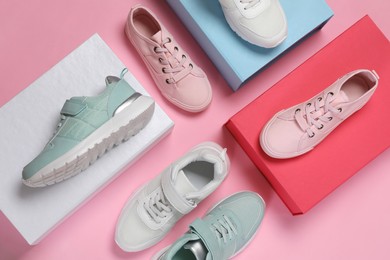 Photo of Flat lay composition with different stylish sports shoes on pink background