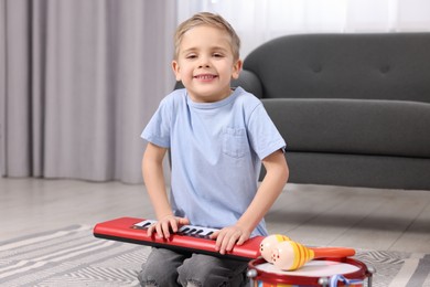 Photo of Little boy playing toy piano at home