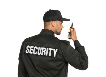 Male security guard in uniform using portable radio transmitter on white background