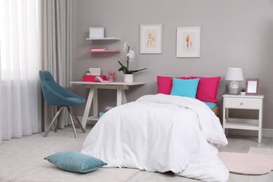 Modern teenager's room interior with comfortable bed and workplace