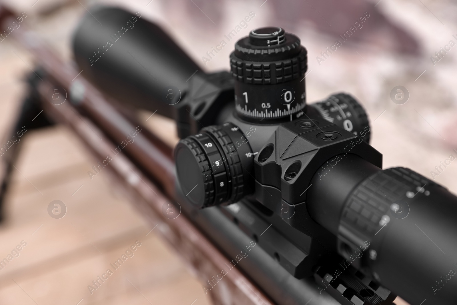 Photo of Closeup view of modern powerful sniper rifle with telescopic sight on blurred background