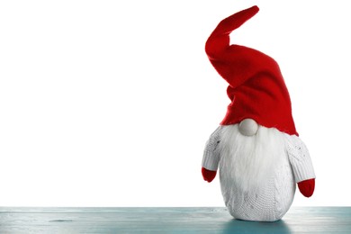 Photo of Funny Christmas gnome on turquoise wooden table against white background. Space for text