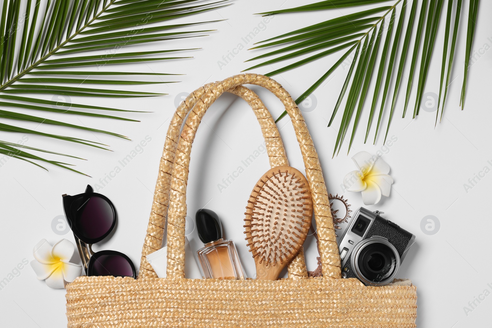 Photo of Flat lay composition with wicker bag, palm leaves and other beach accessories on white background