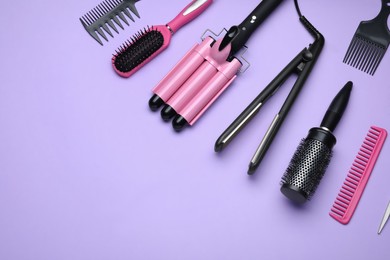 Photo of Flat lay composition of professional hairdresser tools on lilac background, space for text