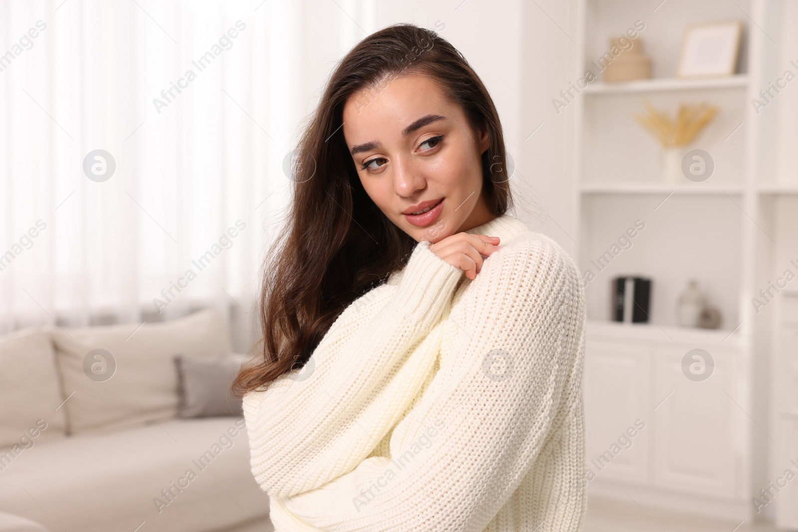 Photo of Beautiful young woman in stylish warm sweater at home