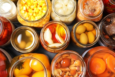 Photo of Open jars with pickled vegetables on grey table, flat lay