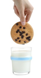 Photo of Woman dipping delicious chocolate chip cookie into glass of milk on white background, closeup