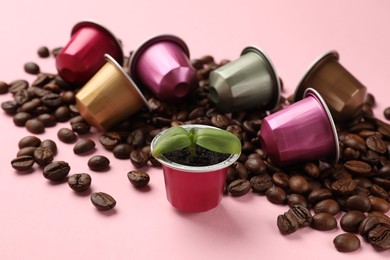 Photo of Coffee capsules, seedling and beans on pink background, closeup