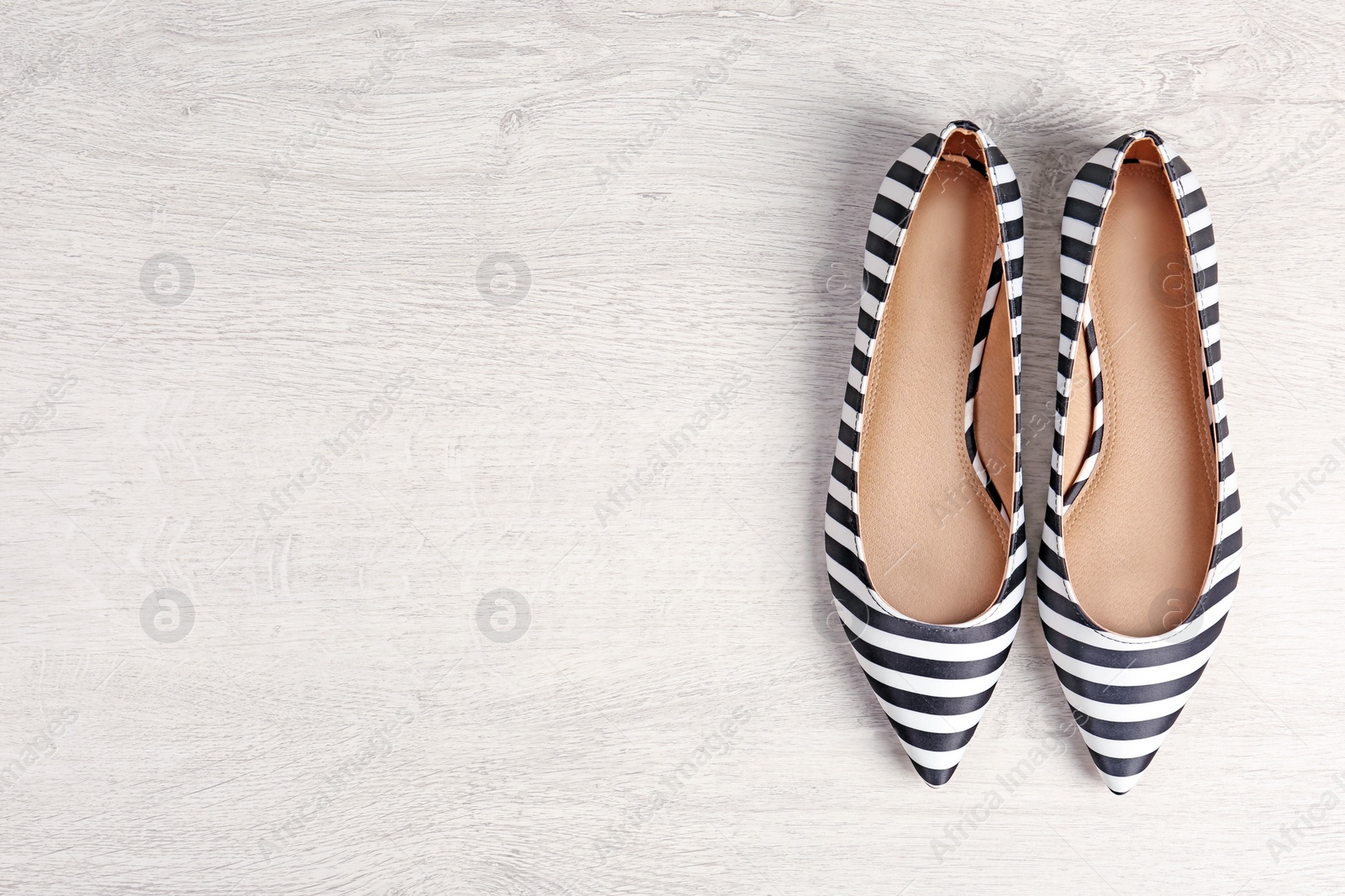 Photo of Pair of female shoes on wooden background, top view