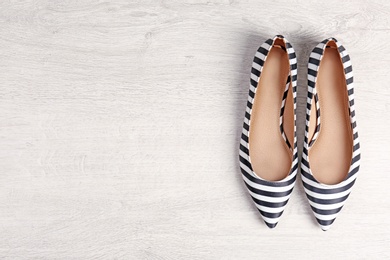 Photo of Pair of female shoes on wooden background, top view