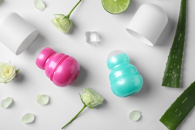 Composition with female roll-on deodorants on white background, top view