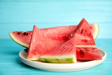 Photo of Yummy cut watermelon on light blue wooden table