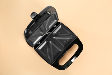 Open sandwich maker on orange background, top view