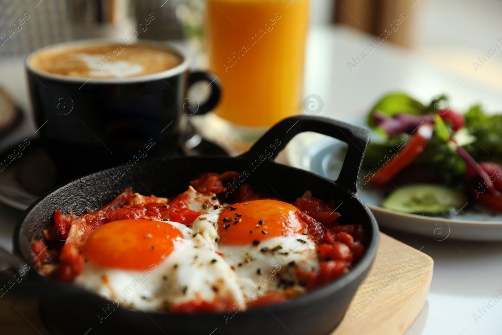 Photo of Tasty Shakshouka served in pan on table, closeup