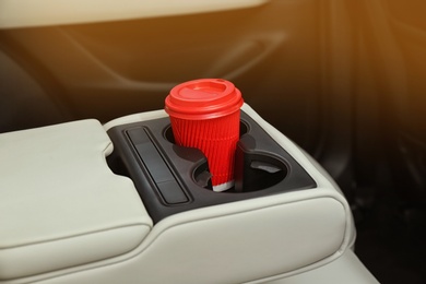 Photo of Takeaway paper coffee cup in holder inside car
