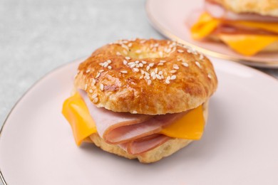 Photo of Delicious bagel with ham and cheese on table, closeup