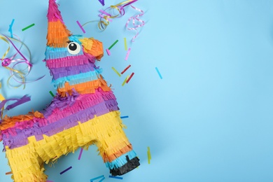 Photo of Bright donkey pinata and confetti on background, flat lay. Space for text