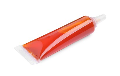 Tube with orange food coloring on white background