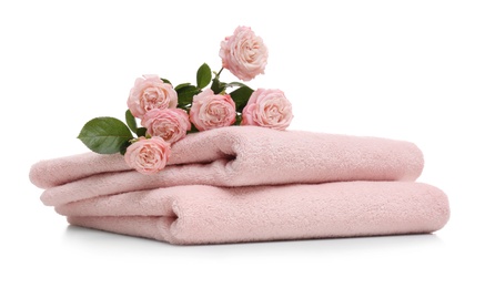 Photo of Clean folded towels with flowers on white background