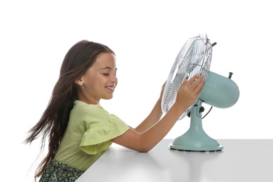 Photo of Little girl enjoying air flow from fan on white background. Summer heat