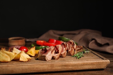 Photo of Cut roasted meat served with sauce and garnish on wooden board. Space for text