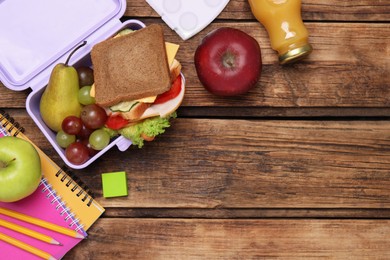 Photo of Flat lay composition with lunch box, tasty healthy food and school stationery on wooden table. Space for text