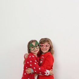 Kids in Christmas sweaters and festive glasses on white background