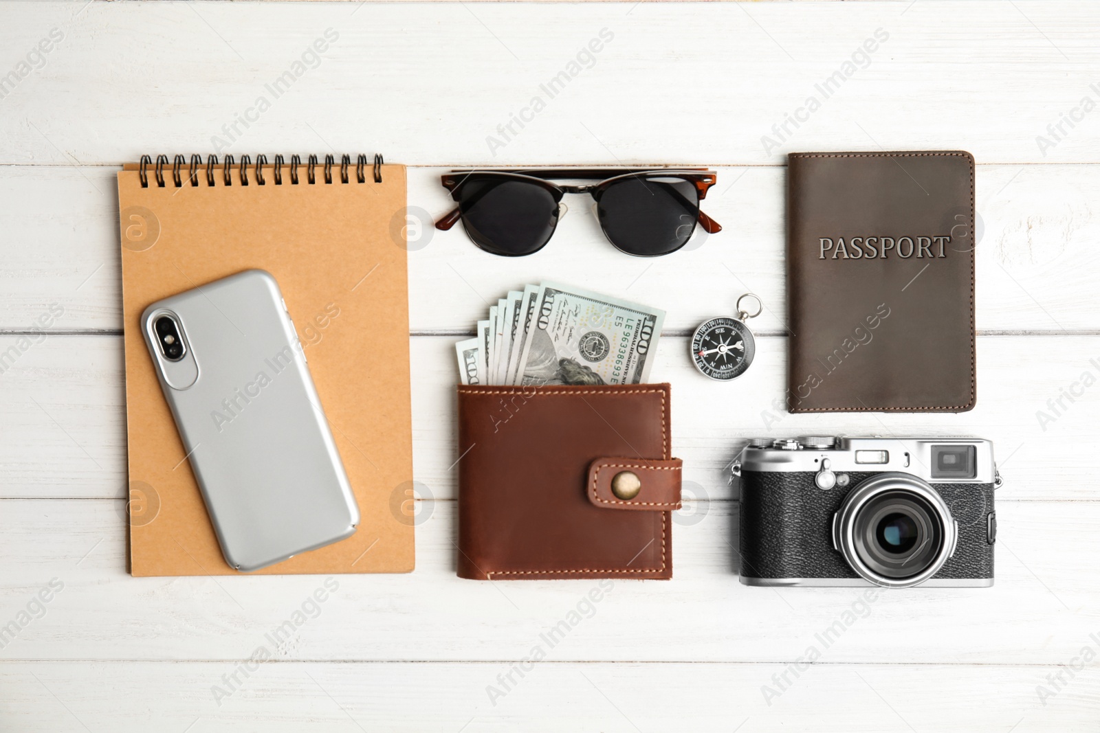 Photo of Flat lay composition with smartphone, passport and camera on wooden background. Travel agency