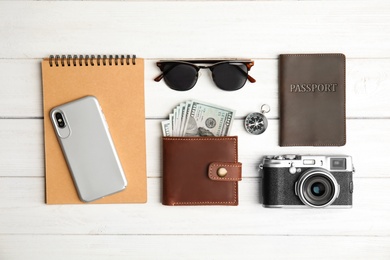 Photo of Flat lay composition with smartphone, passport and camera on wooden background. Travel agency