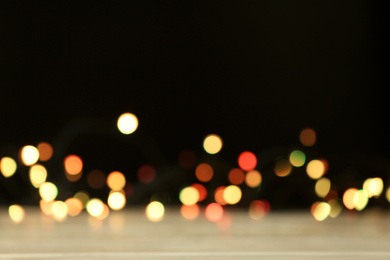 Photo of Blurred view of beautiful lights on black background. Bokeh effect