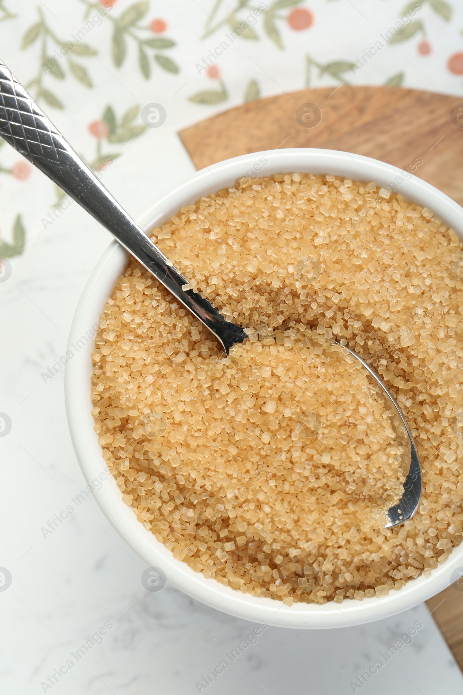 Photo of Brown sugar in bowl and spoon on table, top view