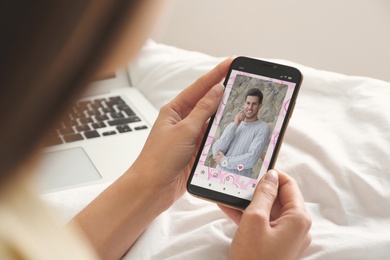 Woman visiting dating site via smartphone indoors, closeup