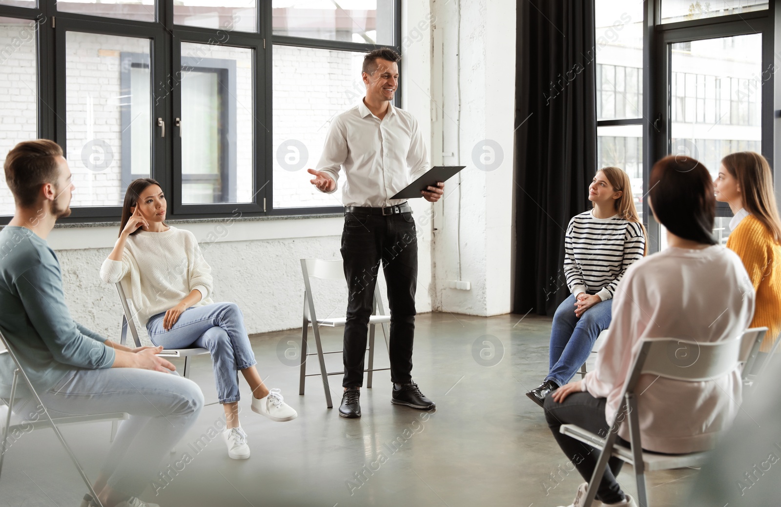 Photo of Psychotherapist working with patients in group therapy session indoors