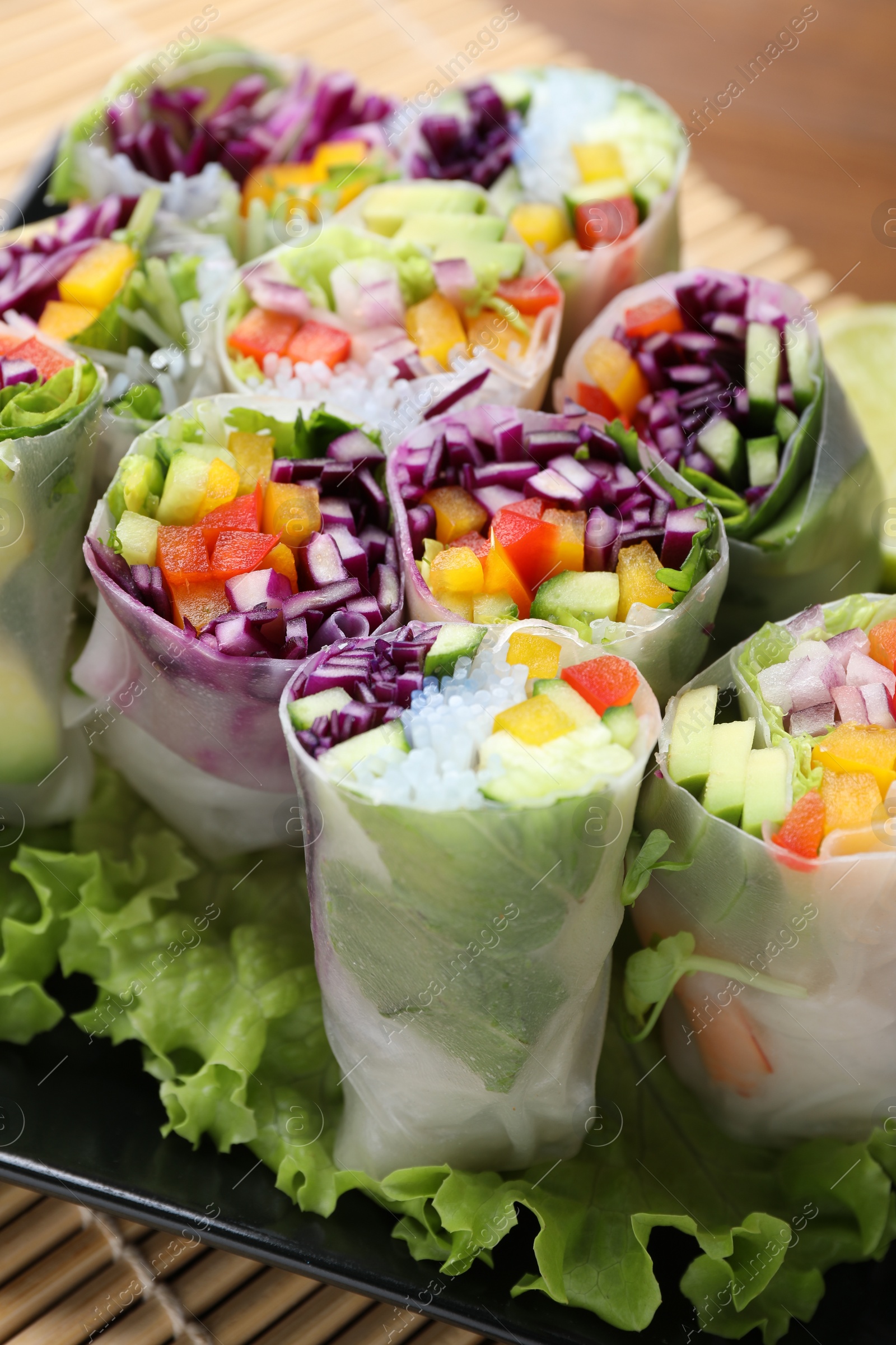 Photo of Delicious spring rolls wrapped in rice paper on table, closeup